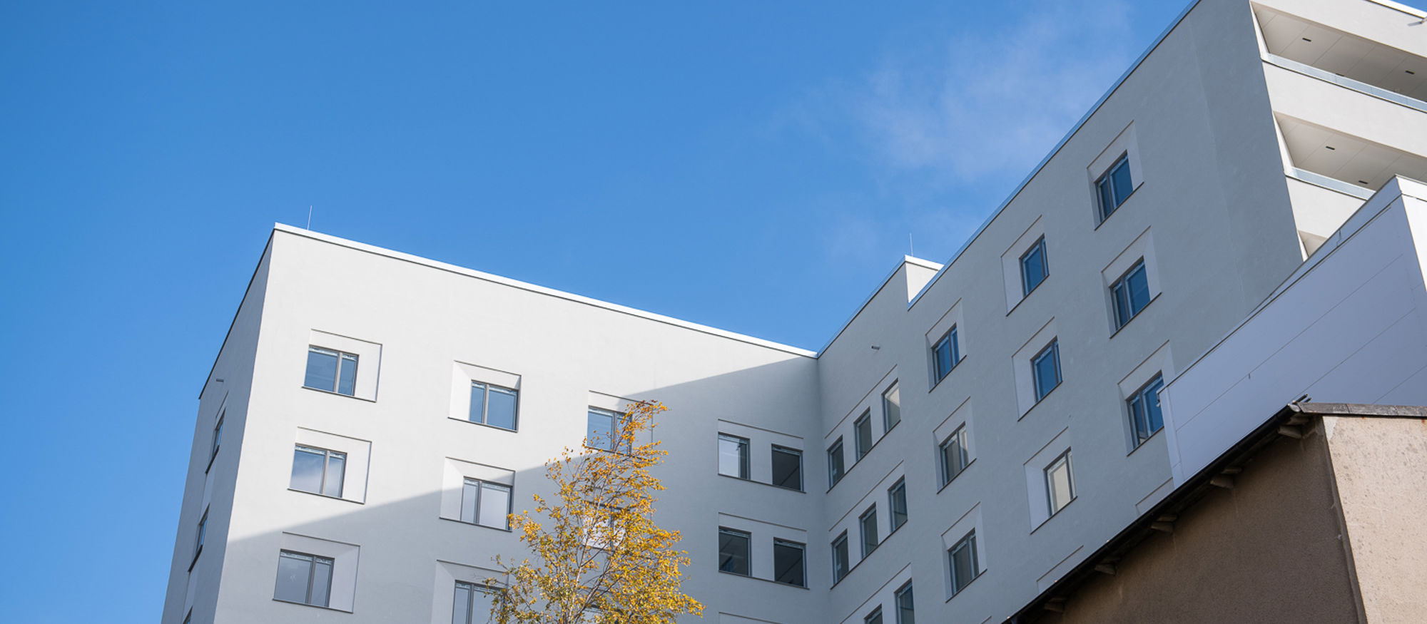Södersjukhuset. Vit flervåningsbyggnad mot klarblå himmel