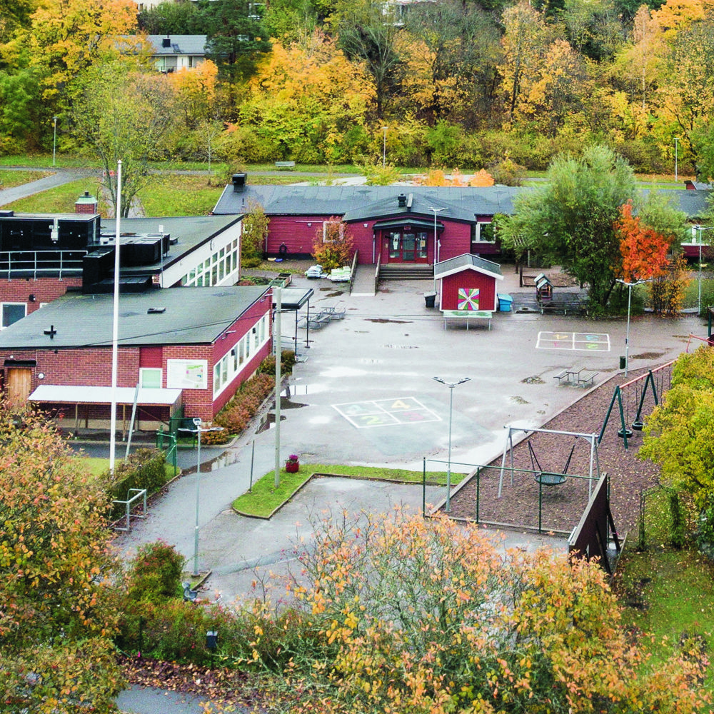 Bo skola. Ingång till röd träbyggnad med vimplar och ballonger