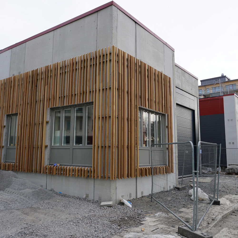 Haninge bussterminal. En envåningsbyggnad i trä och betong under byggnation. 