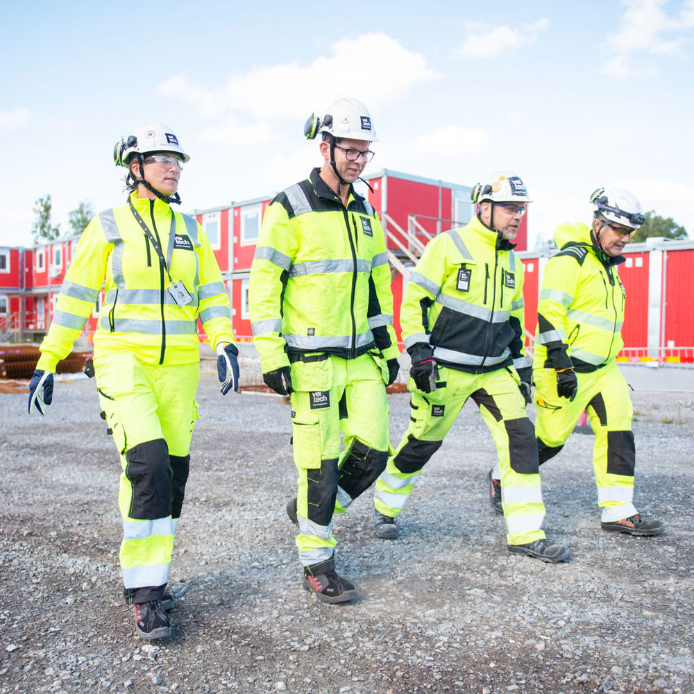 Fyra medarbetare på Veitech utomhus på en byggarbetsplats.