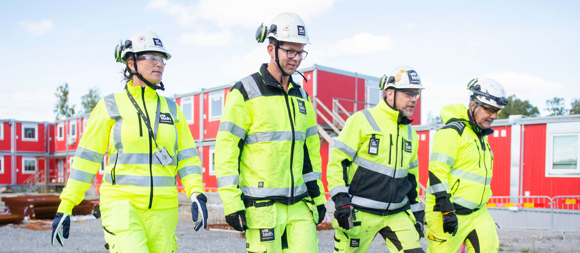 Fyra medarbetare på Veitech utomhus på en byggarbetsplats.