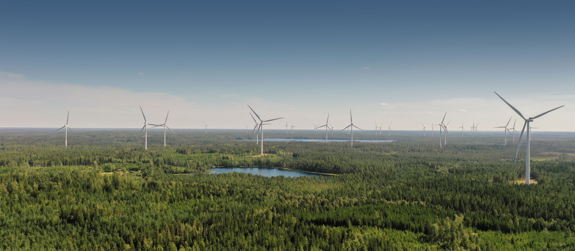 Tvinnesheda vindkraftspark. Ett antal vindkraftverk i skogsmiljö med sjöar